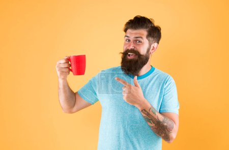 Wahre Kaffeespezialitäten werden zum großen Geschäft. Energiekonzept. Hipster Barista gelben Hintergrund. Kaffeestube vorhanden. Bärtiger Mann trinkt Morgenkaffee. Teezeit. Cappuccino mit dem richtigen Milchanteil.