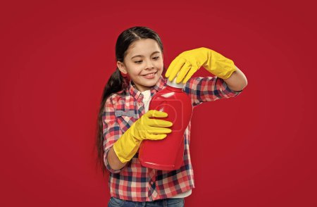 photo of girl household hold detergent. girl household with detergent isolated on red. girl household with detergent in studio. girl household with detergent on background.