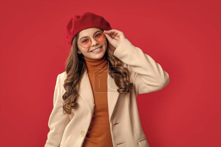 happy young parisian teen girl. photo of parisian teen girl with brunette hair. parisian teen girl isolated on red background. parisian teen girl in studio.