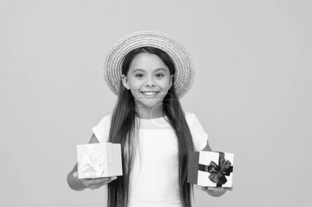 Téléchargez les photos : Cheerful teen girl hold present box on yellow background. - en image libre de droit