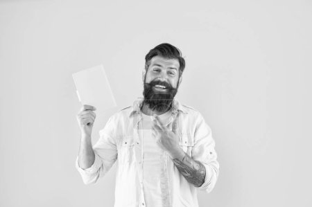 Photo for Cheerful hipster guy point finger on notebook on yellow background, reader. - Royalty Free Image