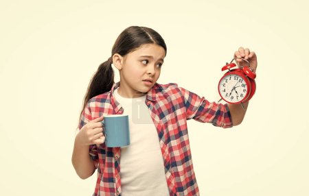 confused girl with morning coffee and alarm on background. photo of girl with morning coffee and alarm. girl with morning coffee and alarm isolated on white. girl with morning coffee and alarm