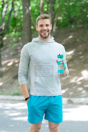 Sportsman man in activewear keep healthy lifestyle by drinking water and do sport or fitness workout outdoor.