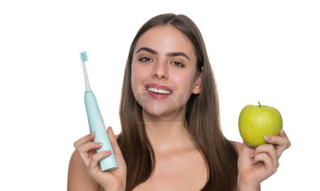 Frau mit weißem Lächeln Zähne putzen mit elektrischer Zahnbürste hält Apfel.