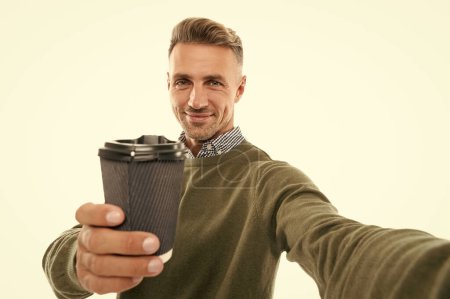 photo of positive selfie man with coffee. selfie man with coffee isolated on white. selfie man with coffee in studio. selfie man with coffee on background.