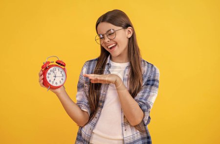 Teen girl hold alarm clock. school time. Teen girl checking the clock. time schedule. Time management for teen girl. Teen girl organizing her schedule with a clock. punctuality.