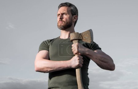 caucasian man with axe. caucasian man hold ax. brutal man on sky background.