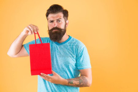 Male motives for shopping appear to be more utilitarian. Aspects can influence customer decision making behavior. Hipster hold shopping bag. Man with purchase. Impulse purchase. Purchase concept.