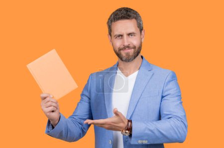 studio shot of businessman holding planner. photo of businessman hold planner. businessman with planner isolated on yellow background. businessman with planner in jacket.