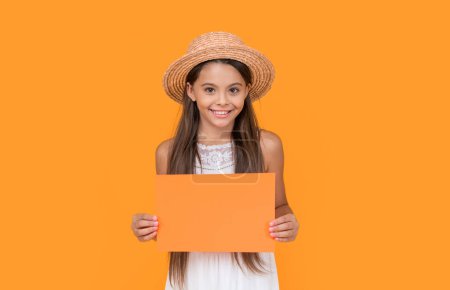 joyeux adolescent enfant avec copie espace sur papier orange sur fond jaune.