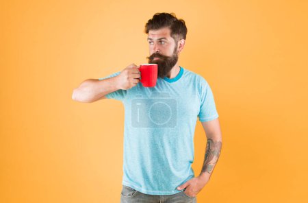 Photo for Tea time. Coffee with right proportion of milk. Morning habits lifestyle. Fanatic of coffee culture. Energy concept. Hipster barista yellow background. Coffee shop. Bearded man drink morning coffee. - Royalty Free Image