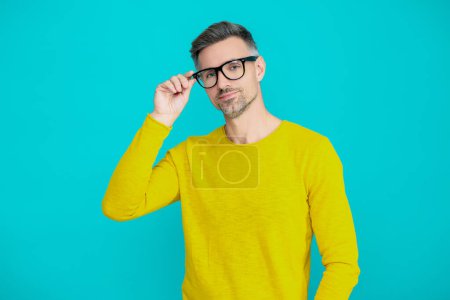 Der Mann sieht mit Brille gut aus. Schwierigkeiten beim Sehen. Brille für den Mann isoliert auf blau. Mit einer Brille gut sehen. Reifer Mann schaut in Brille. Sehschärfe und Sehvermögen. Sehkorrektur. Scharfe Augen.