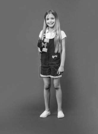 heureux adolescent fille skateboarder isolé sur violet. adolescent fille skateboarder en studio. adolescent fille skateboarder sur fond. photo de jeune fille skateboarder.