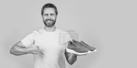 photo of fitness man with sportswear shoes, copy space. fitness man with sportswear isolated on yellow. fitness man with sportswear on background. fitness man with sportswear in studio.