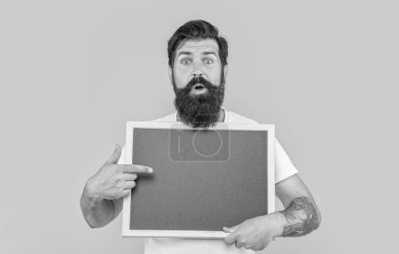 shocked man presenting sale in studio. photo of man presenting sale at blackboard. bearded man presenting sale isolated on yellow. man presenting sale on background with copy space.