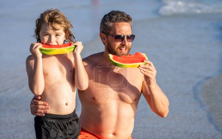 dad and son kid enjoying parenthood together at sea. family bonding and values. Father dad and son eating watermelon. dad father and son on summer parenthood. single dad with son at the beach.