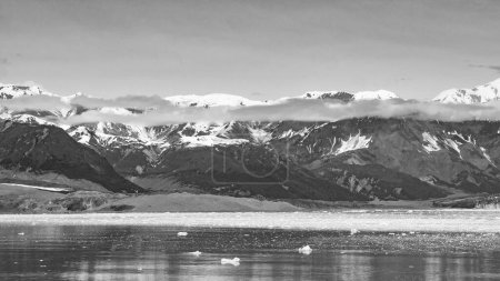 Incredible Hubbard Glacier nature in Alaska, USA. Mountain glacier calving and ice in sea ocean water scenery nature. Mountain coast natural landscape. Glacier bay nature. Snowy mountain peaks.
