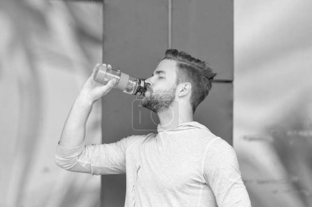 durstiger Sportler, der draußen Wasser trinkt. Foto eines durstigen Sportlers mit Wasser nach dem Training. Durstiger Sportler mit Wasser. durstiger Sportler mit Wasserflasche.