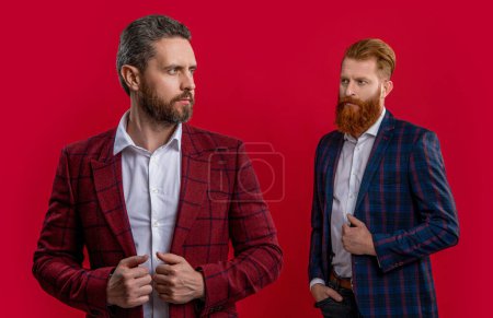 Tuxedo men in elegant suit isolated on red. Tuxedo men in menswear. Tuxedo men wear elegant jacket. Elegant men in formalwear. Elegance and style. Two businessmen at business event. Classic look.