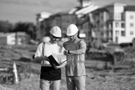architect men discussing construction project deadline. architect men have construction project on clipboard. photo of architect men with construction project. architect men with construction project
