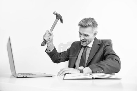 patron en colère frappant ordinateur portable avec marteau dans le bureau.