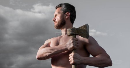 shirtless man with axe. caucasian man hold ax. brutal man on sky background.