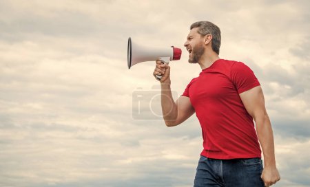 Mann im roten Hemd ruft in Lautsprecher auf Himmelshintergrund.