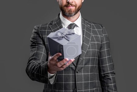 selective focus of businessman with present isolated on red background. businessman hold present in studio. photo of businessman with present. businessman holding present box in suit.