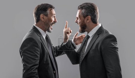arguing businessmen shouting. photo of businessmen arguing with anger. two arguing businessmen isolated on grey background. businessmen arguing in studio.