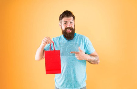 Buy product. Gender differences in purchase decision making. Happy hipster hold paper bag. Bearded man smiling with fashion purchase. Impulse purchase. Shopping concept. Shop store mall boutique.