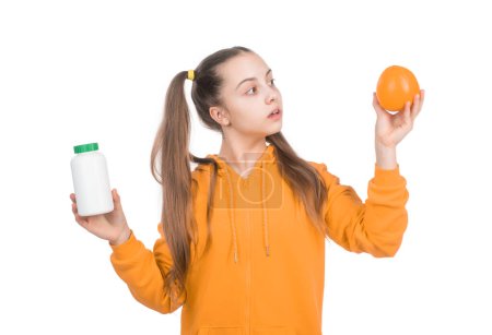 Kind wählt zwischen Orangenfrucht und Vitaminpille in Glasflasche isoliert auf weiß, Pille.