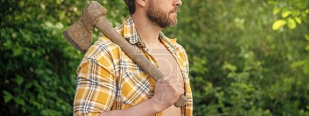 cropped photo of rancher with axe. rancher with axe. rancher with axe wearing checkered shirt. rancher with axe outdoor.