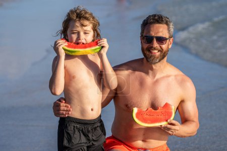 single father with son at the parenthood. happy family day. father dad and son enjoying parenthood time together at sea. Father and son eating watermelon. dad father and son on summer vacation.