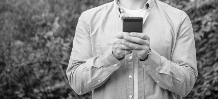 Photo for Man messaging on phone or checking email, copy space banner. photo of man messaging on phone. man messaging on phone. man messaging on phone outdoor. - Royalty Free Image