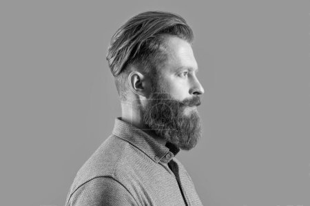 profile of unshaven man with long beard isolated on grey background. studio shot of unshaven man. beard care. handsome unshaven man has beard.
