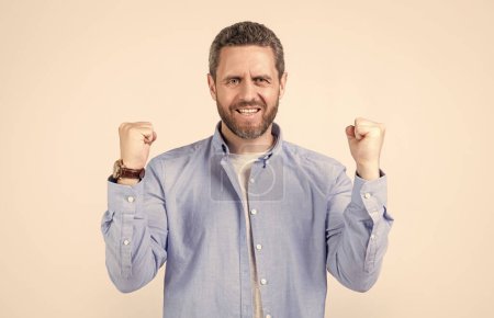 winning man win with yes gesture isolated on grey background. winning man win with yes gesture in studio. photo of winning man win with yes gesture. winning man win with yes gesture wearing shirt.