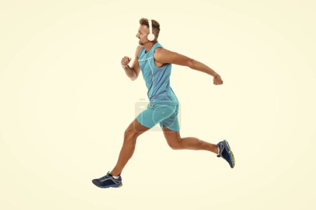 The jogger stretched legs before running. sport jogger listen to music in headphones. The jogger ran at sport training isolated on white. In a morning sport workout jogger run in studio.