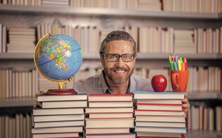 Teacher in school classroom. teacher with book in library classroom. teacher in college. Man with books in library. Knowledge and education. school library. Teachers day. Educational institutions.
