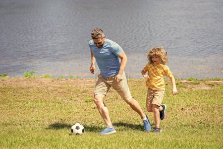 dad have fun with his son. challenges of fatherhood. dad and son enjoying childhood adventures outdoor. dad and son playing football during their childhood. Childhood memories of son and his dad.