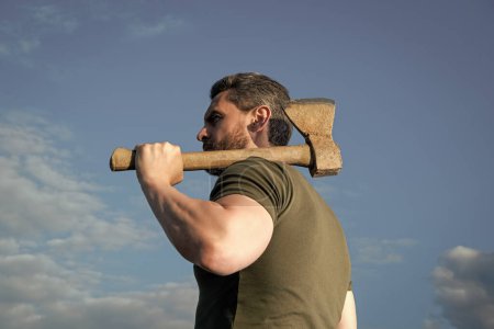 back view of man with axe. woodman man hold ax. brutal man on sky background.