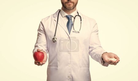 Ernährungsberaterin mit Apfel und Pillen. Ernährungsberaterin isoliert auf weiß. Ernährungsberaterin mit Pillen. Ausgeschnittene Ansicht.