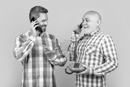 Foto von fröhlichen Männern mit Telefonkontrastruf. Männer mit Telefonkontrast telefonieren isoliert auf gelb. Männer mit Telefonkontrastgesprächen im Studio. Männer mit Telefonkontrastruf im Hintergrund.