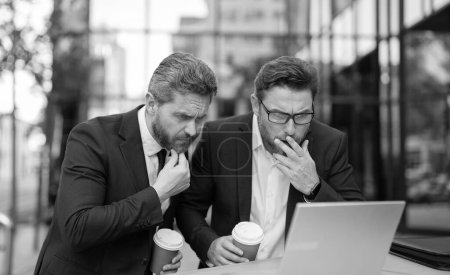 Photo for Confused trader business men freelancing online with laptop. photo of trader men freelancing online. two trader men freelancing online. trader men freelancing online outdoor. - Royalty Free Image