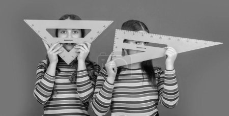 Photo for Happy school students hold math tool of triangle. - Royalty Free Image
