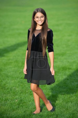 Stylish teen girl has long hair in glasses posing as model in spring outdoor.