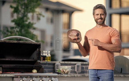Koch präsentiert seine Grilltechniken bei Kochveranstaltung. Mann grillt gern. Mann grillt sein Lieblingsfleisch. Meisterhafte Grilltechniken. Knochensteak.