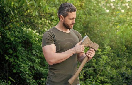 man holding ax. man with ax wearing shirt. man with ax outdoor. photo of man with ax.