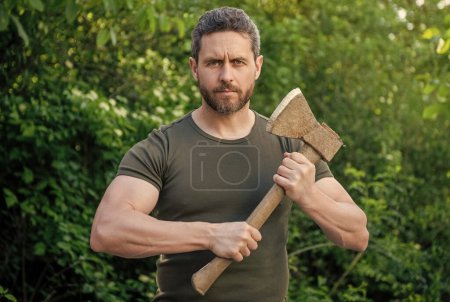 photo of caucasian man with axe wearing shirt outdoor.