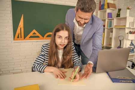 girl with teacher in school classroom use laptop.