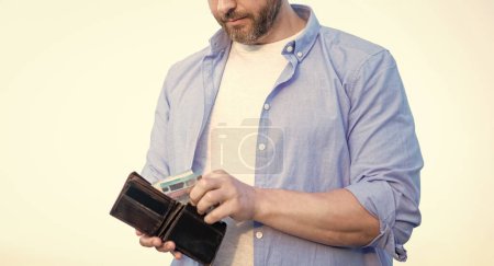 Ernsthafter Mann entwendet Bargeld aus Brieftasche.